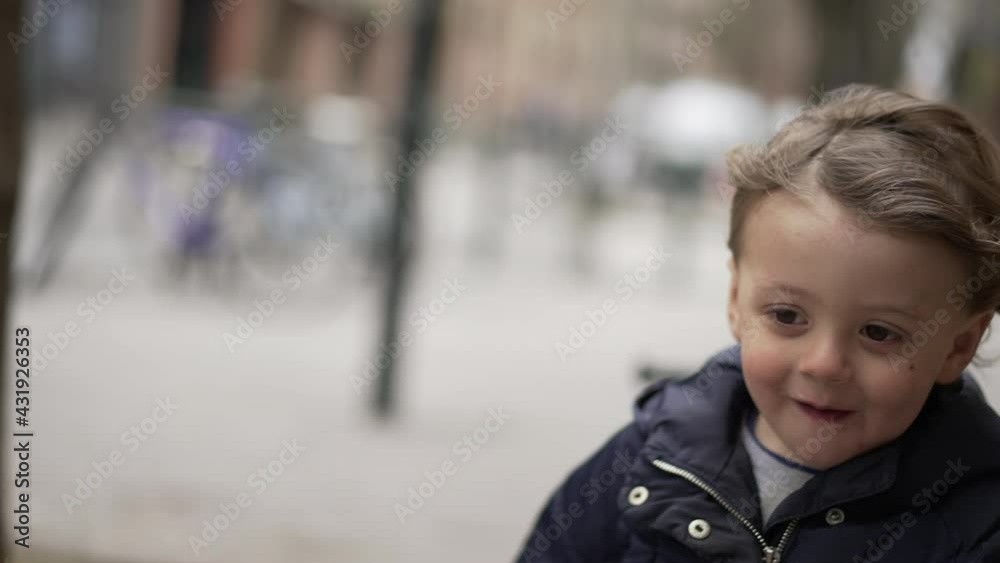 Little child feeling the breeze in face walking outside in sidewalk Little child feeling the breeze in face walking outside in sidewalk