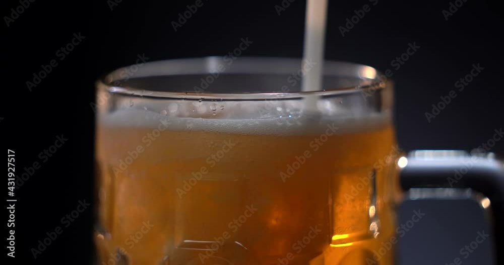 Bartender pouring beer into glass with bubbles close up Bartender pouring beer into glass with bubbles close up
