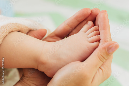Small foot of a newborn baby in the hands of an adult. © Svyatoslav Balan
