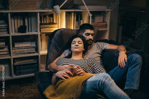 couple relaxing at home with cosmetic face mask applied on faces