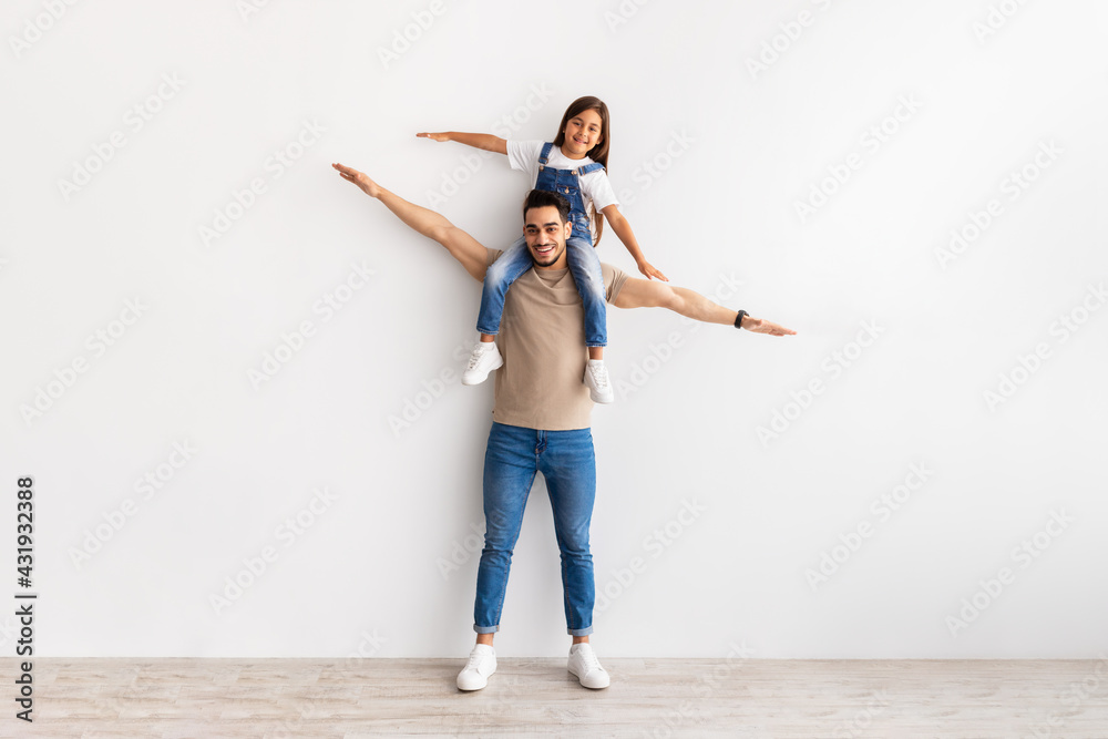 Cheerful Man Riding Excited Daughter On His Shoulders