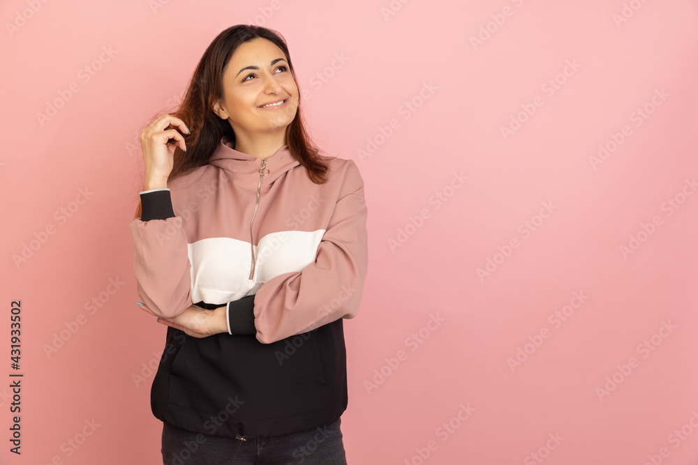 Young woman's portrait on pink studio background. Concept of human emotions, facial expression, youth, sales, ad.