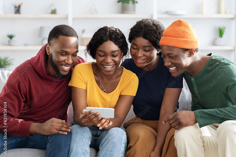 Happy african american friends using mobile phone together