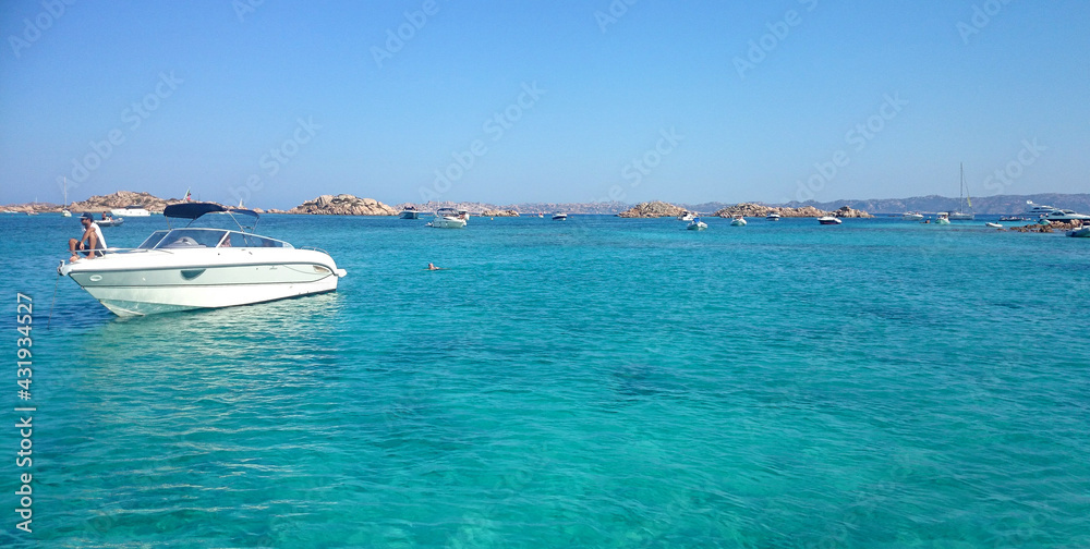 emerald sea with rocky panorama and boats sardinia