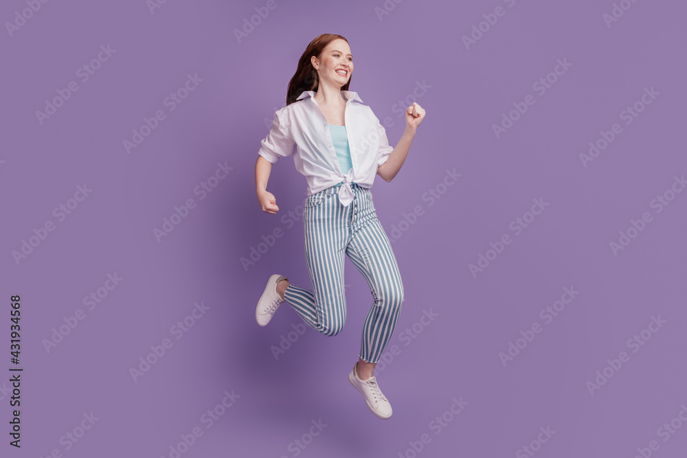 Portrait of active funny positive lady jump run on violet background