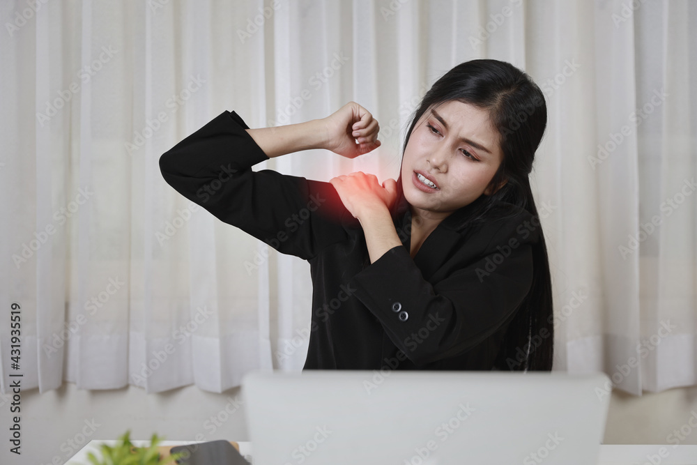 Young asian stressed businesswoman feeling pain or having problem with part of body arm shoulder or neck after working on computer for too long time. Office syndrome concept Young asian stressed businesswoman feeling pain or having problem with part of body arm shoulder or neck after working on computer for too long time. Office syndrome concept