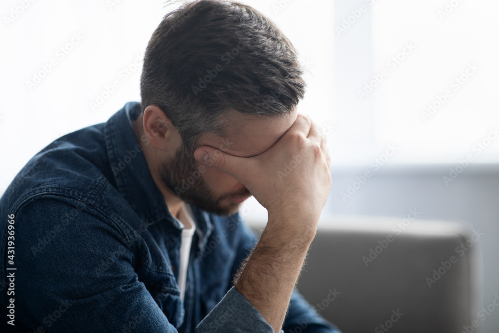 Upset man having headache, touching his forehead Upset man having headache, touching his forehead