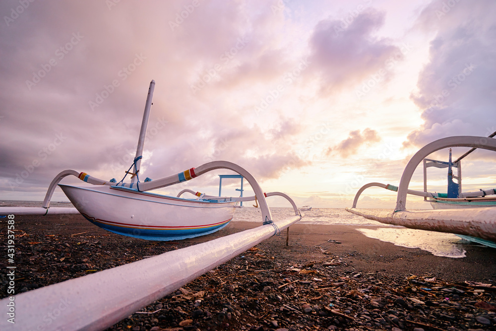 Beautiful sunrise. Ocean, beach and indonesian fishing boats.