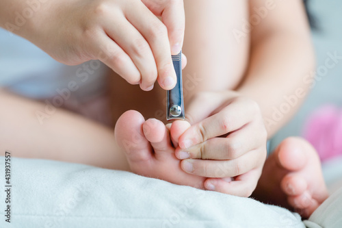 clean nails.kid child girl cutting nails using stainless steel nail clipper at home.Hygiene.virus bacteria in nails.Toe nail cutting with a cutter.sanitizer hand.coronavirus covid19.skin care.