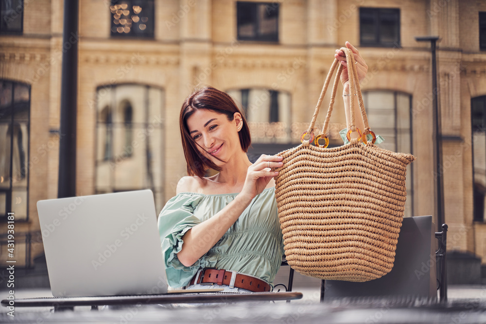 Girl showing bag on video call - obrazy, fototapety, plakaty 