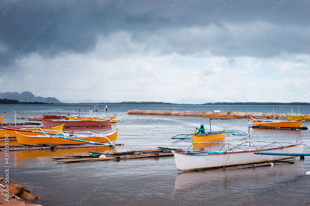 Fototapeta premium Tropical fishing boats harbour at rainy day. Siargao, Philippines.