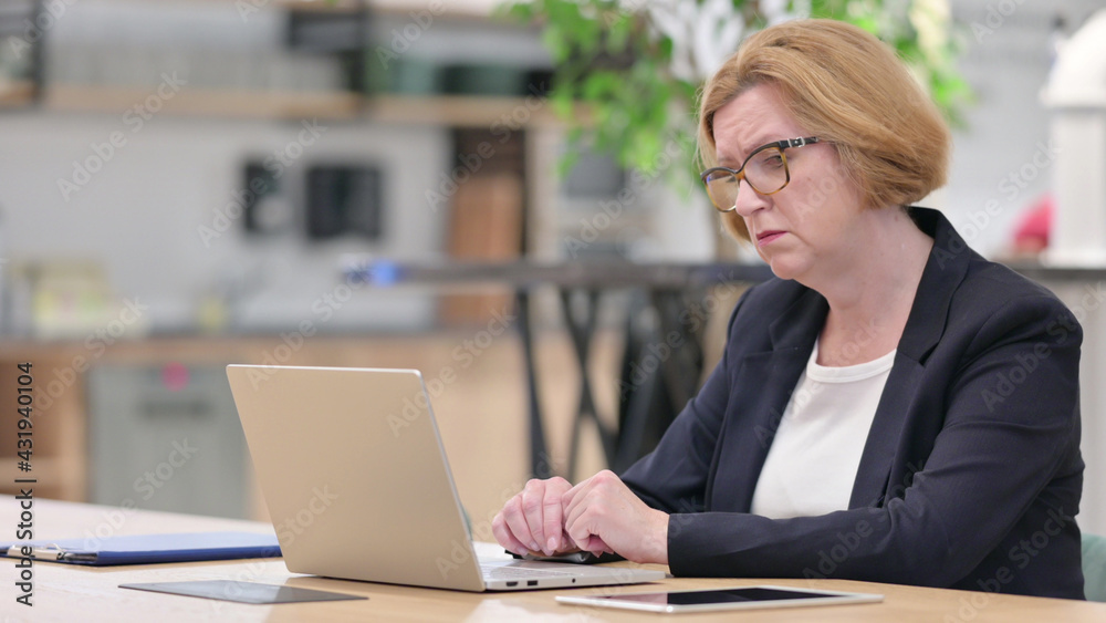 Old Businesswoman having Loss on Laptop in Office Old Businesswoman having Loss on Laptop in Office