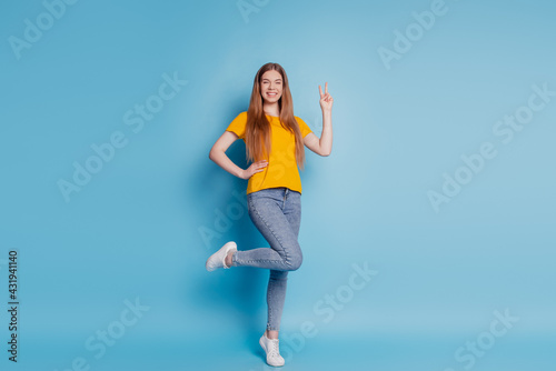 Portrait of cheerful dream lady show v-sign wear casual clothes on blue background