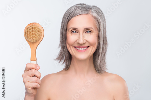 Photo of attractive charming nice old woman hold had wooden brush smile massage isolated on grey color background