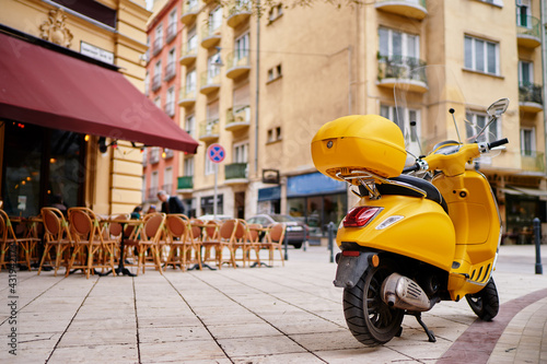 Motorbike outdoor. Yellow retro style scooter on the town street.