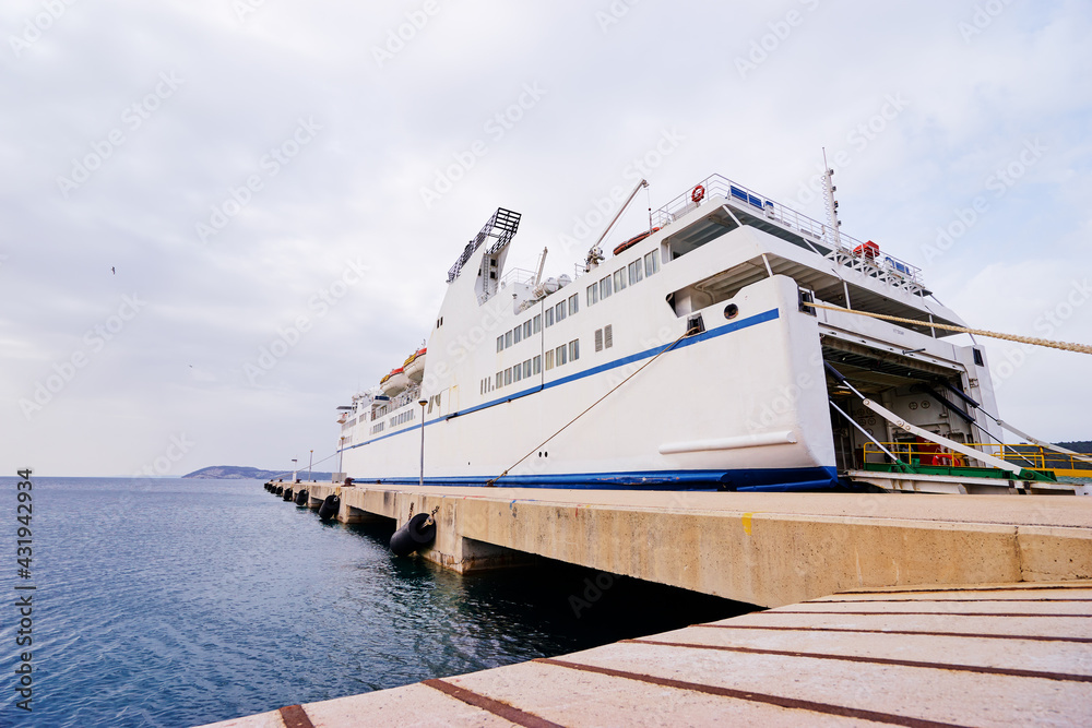 Naklejka premium Ferryboat loading or unloading by a port pier. Concept of transportation and traveling.