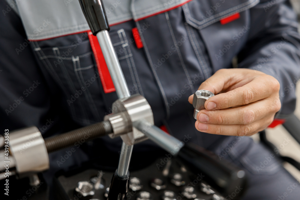 A specialist in a metrology and standardization laboratory selects a threaded connector for a pressure calibration and test instrument. Checking international quality standards ISO.