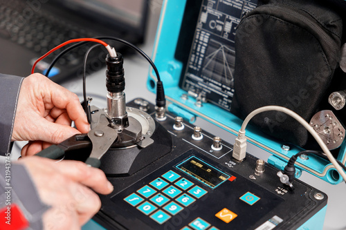 Canvas Print A specialist in the laboratory of metrology and standardization checks the resistance of the sensors to vibrations and shocks on a special test bench