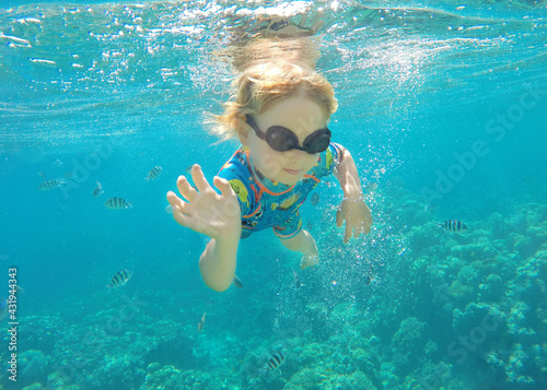One toddler boy caucasian blond hair snorkeling under sea water. blue sea corals small boy swimming. Summer vacation, outdoor activities, sport, happy holidays, love nature, child nature concept.