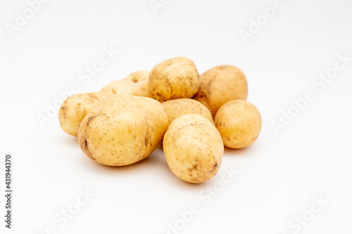 Fresh raw yellow potatoes on a white background. Harvest young potato.