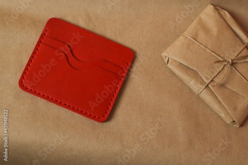 Leather wallet with a package wrapped in kraft paper 
