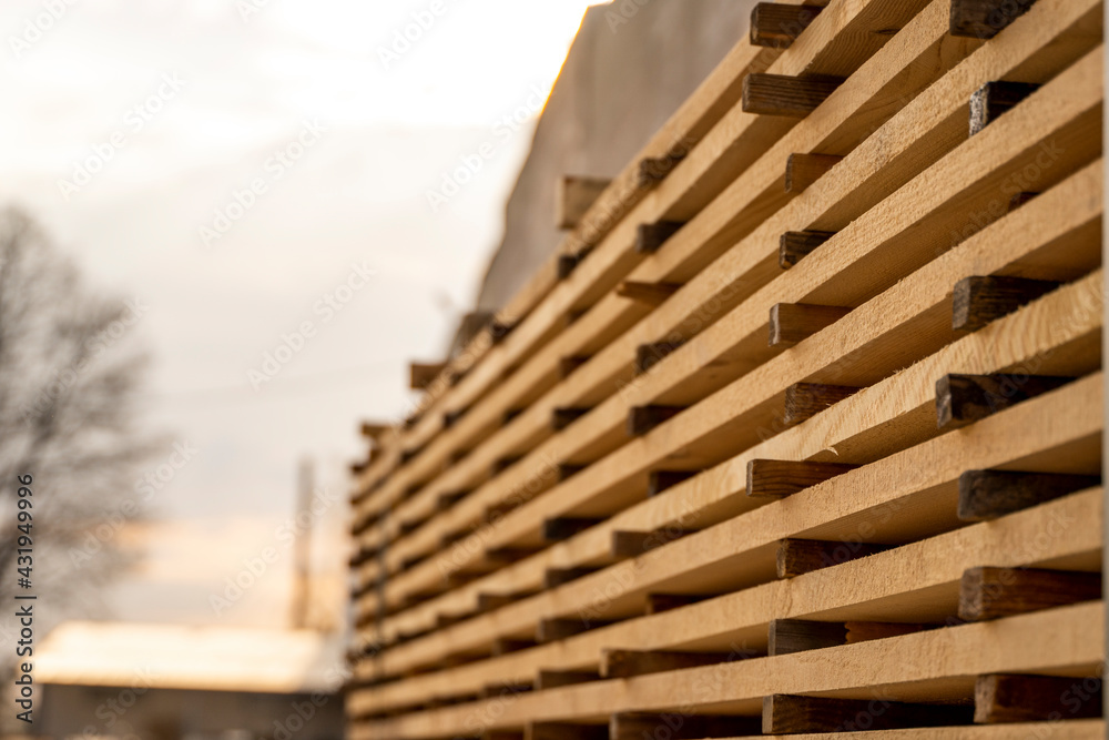 Storage of piles of wooden boards on the sawmill. Boards are stacked in a carpentry shop. Sawing drying and marketing of wood. Pine lumber for furniture production, construction. Lumber Industry. Storage of piles of wooden boards on the sawmill. Boards are stacked in a carpentry shop. Sawing drying and marketing of wood. Pine lumber for furniture production, construction. Lumber Industry.