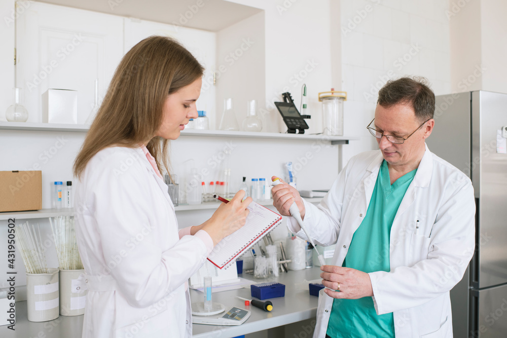 Researchers in white coats working in lab Researchers in white coats working in lab