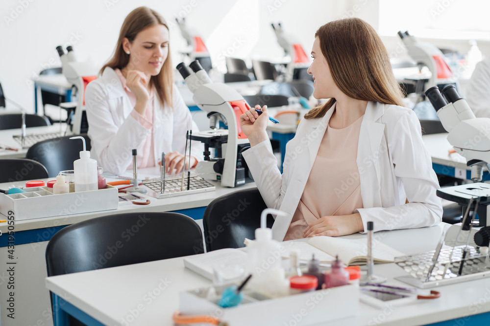 Young female researchers talking in science class Young female researchers talking in science class