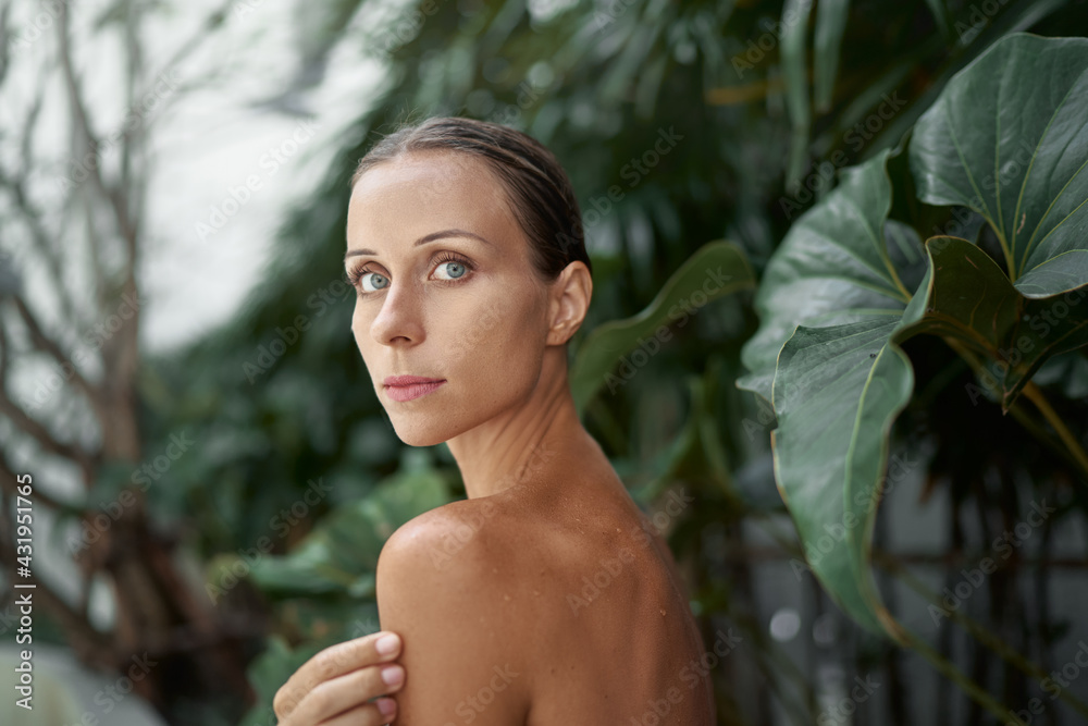 Close up outdoor portrait of young beautiful woman against green tropical leaves. Close up outdoor portrait of young beautiful woman against green tropical leaves.