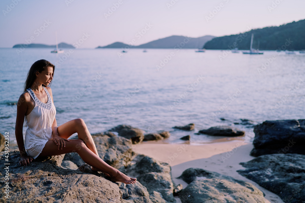 Outdoor portrait of young beautiful woman with long hair on the sea beach.