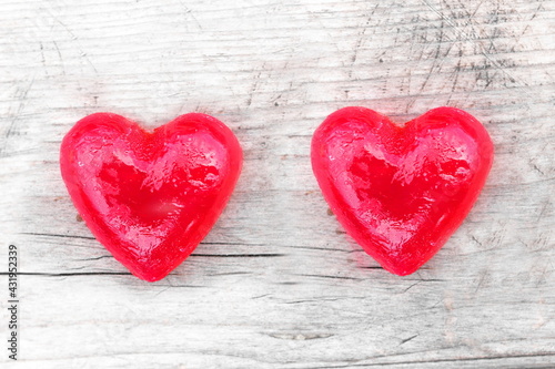 Two red hearts on natural wooden background as loving heart symbol for wedding greeting card with heart symbol or Valentine's Day card with beautiful red hearts