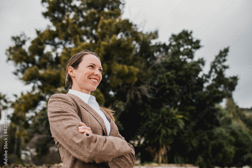 Smiling businesswoman with arms crossed looking away Smiling businesswoman with arms crossed looking away