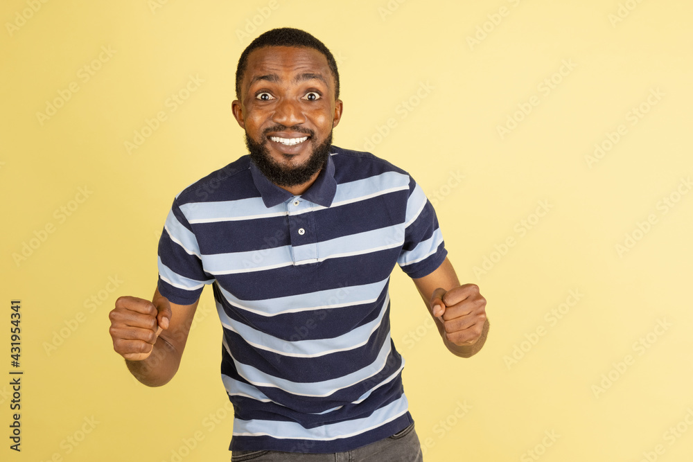 Fototapeta premium One African young man posing isolated over yellow studio background with copyspace for ad