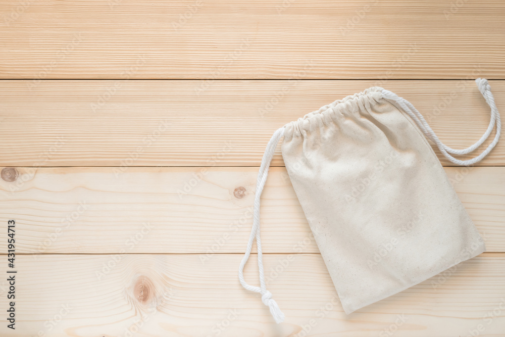 Drawstring tote bag mockup, small eco sack with string made from natural cotton fabric canvas burlap cloth flat lay on white wood background from top view Drawstring tote bag mockup, small eco sack with string made from natural cotton fabric canvas burlap cloth flat lay on white wood background from top view