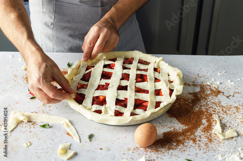 Arms of man preparing strawberry sweet pie
