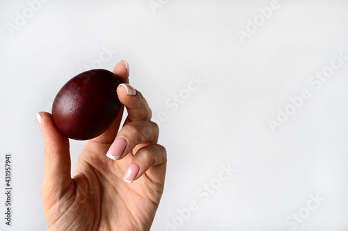 woman's hand holds an Easter colored egg isolated on a white background. Space for text