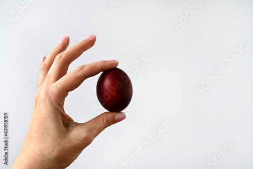 woman's hand holds an Easter colored egg isolated on a white background. Space for text