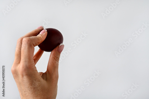 woman's hand holds an Easter colored egg isolated on a white background. Space for text