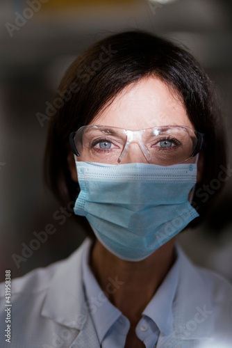 Female scientist with protective eyewear at laboratory during pandemic photo