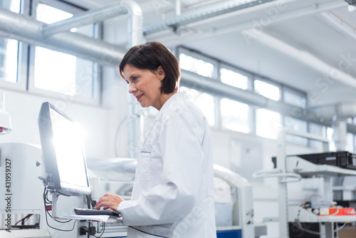 Female technician working on computer at factory
