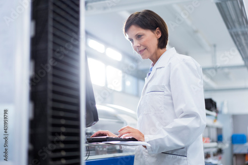 Female scientist using computer at laboratory