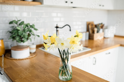 daffodils bouquet in vase on the table white kitchen view