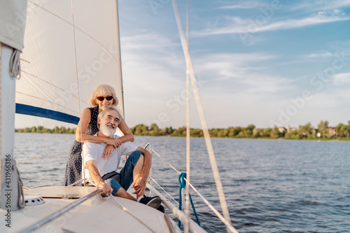 Romantic vacation and luxury travel. Senior loving couple sitting on the yacht deck. Sailing the sea. © luengo_ua