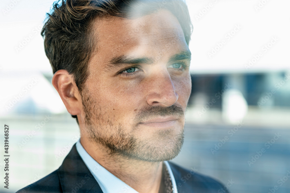 Close-up of businessman looking away while standing at office Close-up of businessman looking away while standing at office