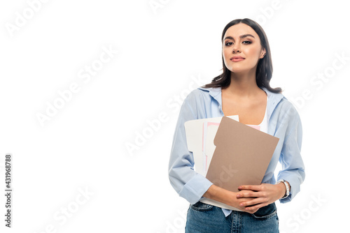 positive businesswoman in casual clothes looking at camera while holding documents isolated on white.