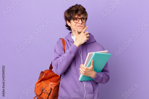 young student man thinking, feeling doubtful and confused photo