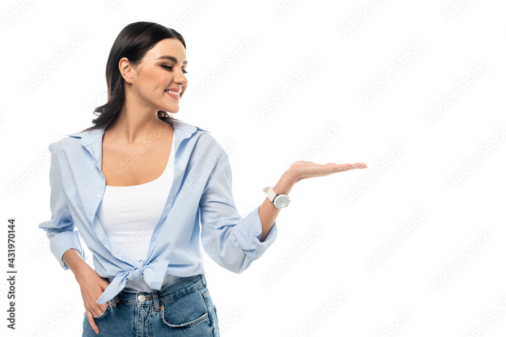 smiling woman pointing with hand while standing with hand in pocket isolated on white. smiling woman pointing with hand while standing with hand in pocket isolated on white.