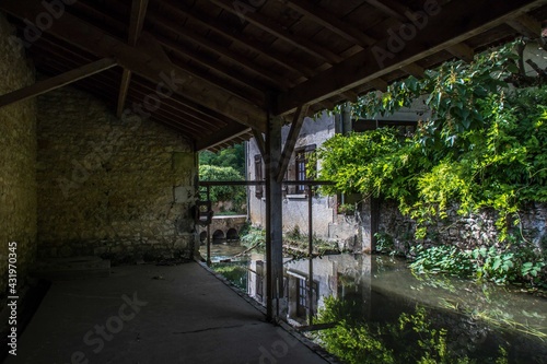 beautiful river scene though an old wash house in rural france