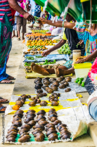 PapuaÔøΩNew Guinea, Milne Bay Province, Alotau, Person buying tropical fruits at market photo