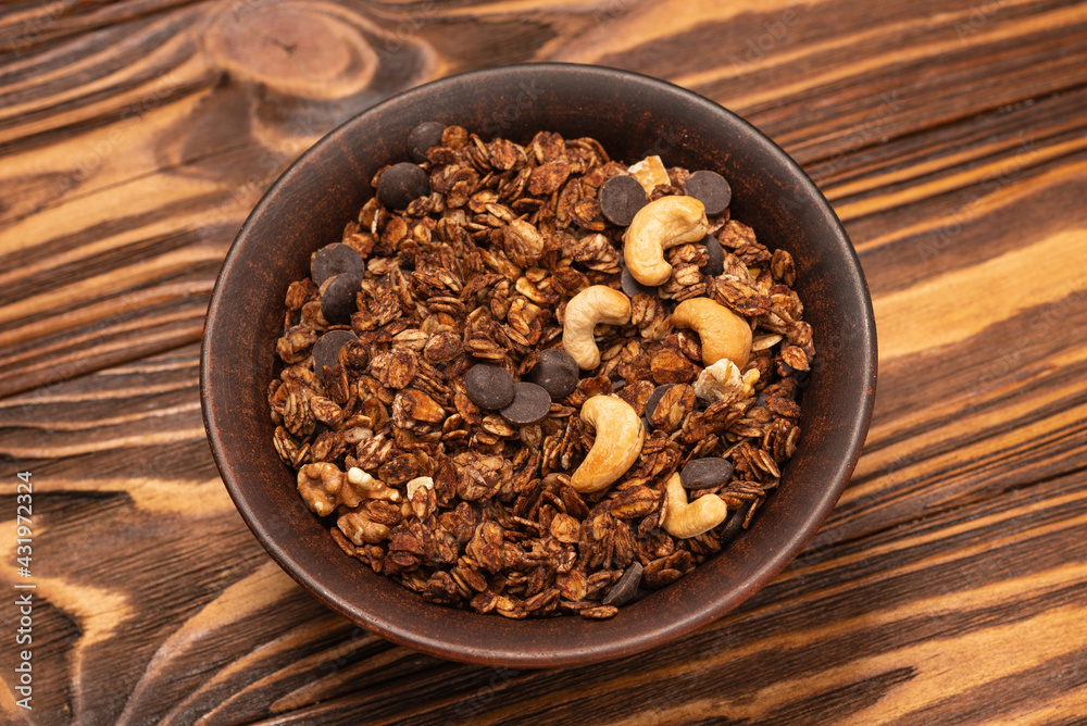 Chocolate granola cereal with nuts in a bowl. Chocolate granola cereal with nuts in a bowl.
